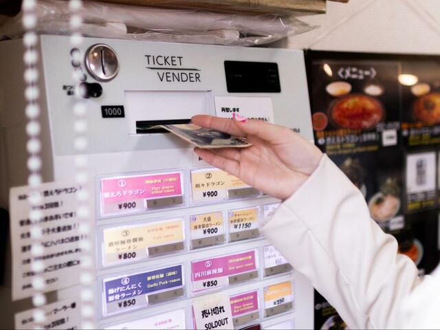 食券にお金を入れるぱるちゃむさん