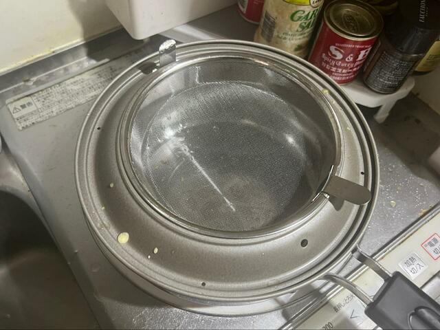 【揚げてお仕舞い】油こしの準備。鍋に油飛びガードをセット、油こし網をのせます