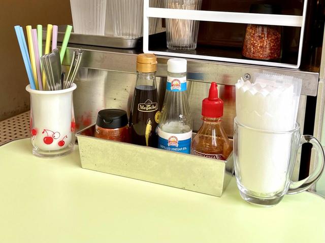 【88 Asia】各テーブルには東南アジア的な調味料が。左から唐辛子、ナンプラー、酢、シラチャー。置かれ方も東南アジアチック