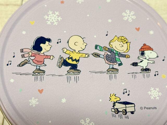 【カルディ／スヌーピー クリスマスラウンドティン チョコチップクッキー】ふたにはスケートを楽しむスヌーピー＆ピーナッツの仲間たちが♪