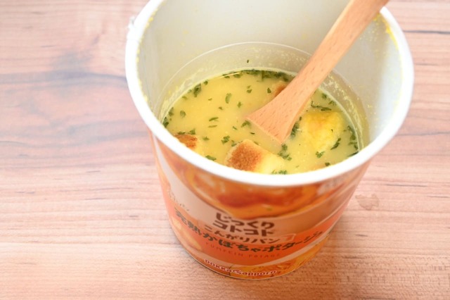 【かぼちゃスープのカレーうどん】カレー粉を入れ、線の半分くらいまで熱湯を注ぎ、よくかき混ぜる