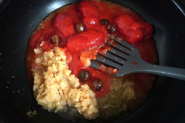 【カンロ飴レシピ：バターキーマカレー】ホールトマト缶、水、カンロ飴を加え、トマトを潰しながら混ぜて飴を溶かす。少し水気が減るまで5分ほど煮込む