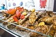 フィッシュマーケットさながらの牡蠣やロブスターなどを所狭しとのせたアイスベッドがライブ感を演出