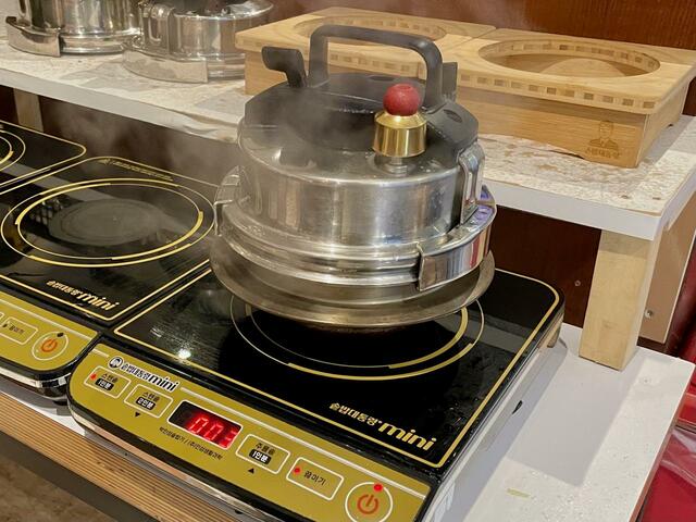 【釜めし 大統領】釜めしの注文がはいると圧力鍋タイプの釜をIHコンロにかける。炊きあがりまで約7分