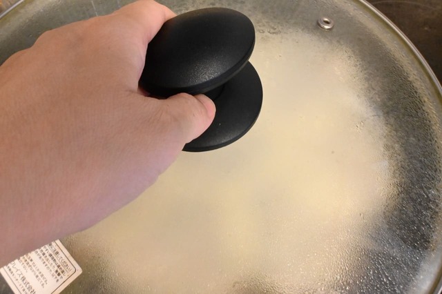 【ボンカレー公式アレンジレシピ「フライパンジャンボカレー餃子」】強火にかけ、パチパチ言い出したら水を入れてふたをする