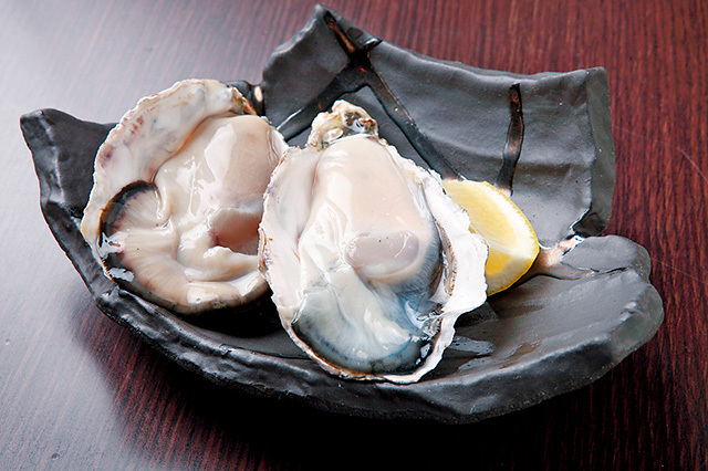 鉄板居酒屋 牡蠣 やまと（大阪・天王寺） 『生ガキ』（650円/2個）レモン、ポン酢、ニンニク醤油、サルサソース、わさび醤油で味わえる。