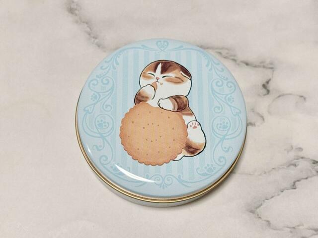 翁ビスケットを食すにゃんこのイラスト入り。口の横にビスケットのカスをつけている姿がキュート!