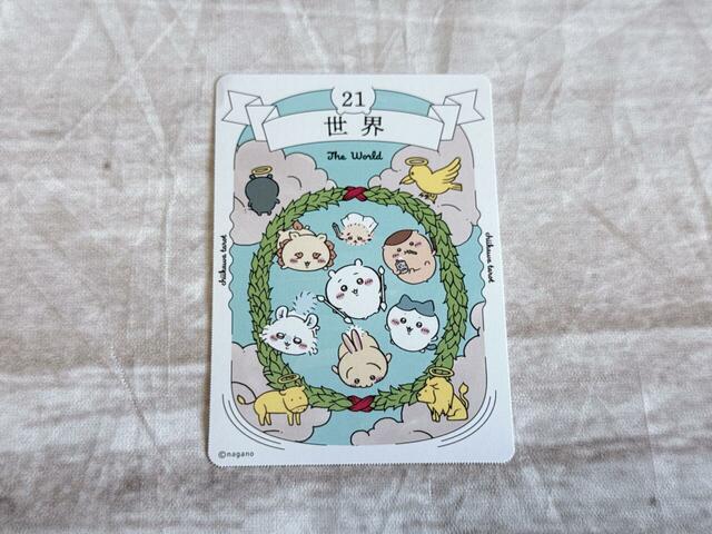 「21．世界」は完成や目標達成を意味するカード。基本的な絵柄の構成は『ウェイト版』タロットを模していますが、真ん中のイラストは異なります。空を飛ぶちいかわたちがかわいい♪