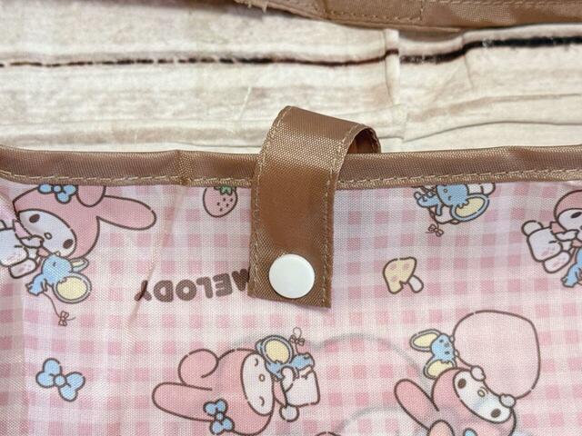 開口部にはスナップボタン付きのストラップが付いており、荷物を入れたあとに留められる仕様【しまむら ショッピングバッグ（マイメロディ）】