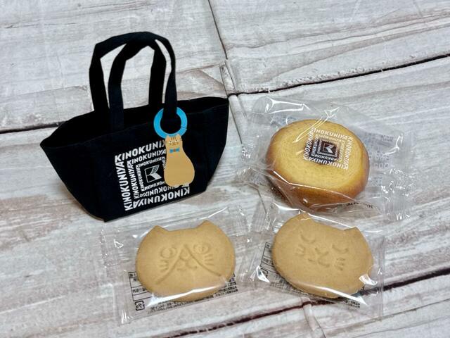 ねこのチャームがついたミニスイーツバッグに、ねこの顔型クッキー、バウムクーヘン（プレーン）が入ったセット