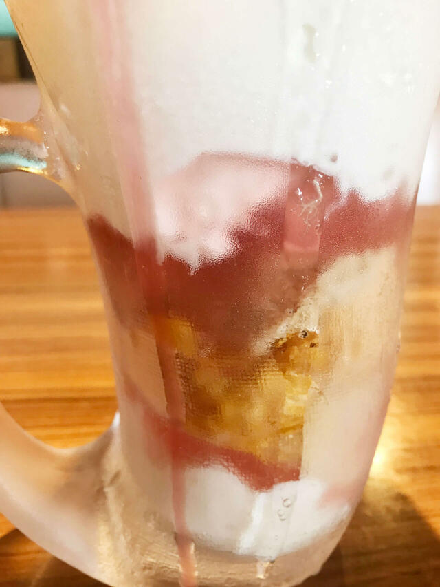 下部には赤みがかったソースのようなものやパフっぽいものなどバリエーション豊かな層が。【びっくりドンキーのジョッキパフェ（ピーチ）】