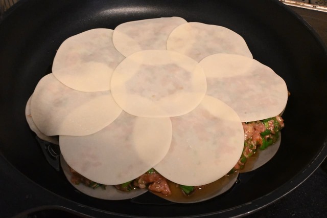 【ボンカレー公式アレンジレシピ「フライパンジャンボカレー餃子」】餡をのせ、さらに餃子の皮をのせる