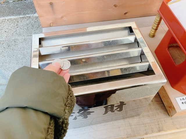 【蛇窪神社（へびくぼじんじゃ）】お賽銭（二百円からと指定がありました）を入れ、金色の大きな五円玉のような「白蛇種銭」を1つ手に取ります