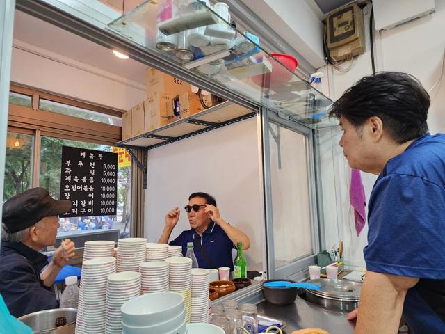 右手が「トゥンスンネ」の女将。以前の店とは違いイスとテーブルも置いてあり、純粋な立ち飲み屋とはいえなくなった