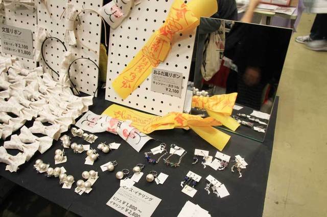 「新星急報社」のブース。キョンシーのお札や文学作品をリボンにしたブローチやカチューシャが並べられています。
