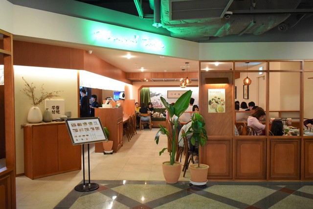 ロッテホテルの向かい辺りに位置するオフィスビルの地下にある『ムウォル食卓　乙支路店』の入口。隣りにはおしゃれなカフェやステーショナリーの店がある