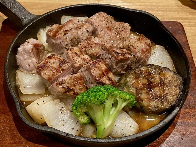 ソテーしたタマネギの上に豚ステーキと揚げナスとブロッコリーが盛られていた