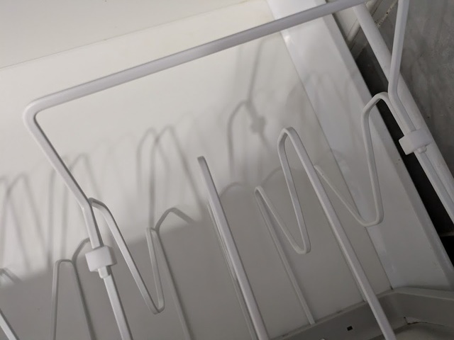 【山崎実業 tower シンク下 伸縮鍋蓋＆フライパンスタンド】シリコンストッパーをセットした仕切りに、フライパン用の持ち手置きを差し込みます