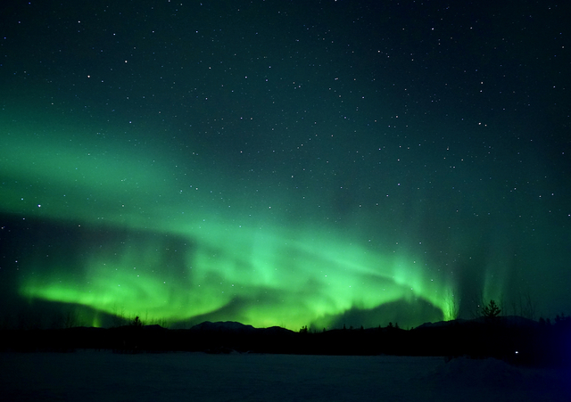 ツアーの観測場所から見えたオーロラ。肉眼でオーロラのダンスがはっきりと見えたが、これでも「10段階評価で4（10が最高評価）」程度だそう。