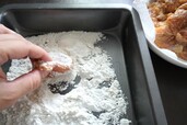 【〈塩分ハーフ〉ぐっち夫婦レシピ：味噌から揚げ】バットに薄力粉と片栗粉を入れて混ぜる。ペーパーで挟んで水気をしっかりとった鶏肉を入れ、粉を丁寧にまぶしてはたく