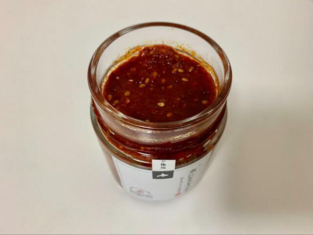 【気になるキムチ　サーモン×アボカド（甘口）】ごまの入ったキムチが瓶の中にたっぷりと入っています