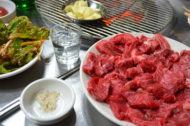 牛焼肉専門店の肉と副菜。左下から塩とゴマ、その上がサンチュの和え物。最近はいい肉を出すことに注力し、副菜をシンプルにする店も少なくない