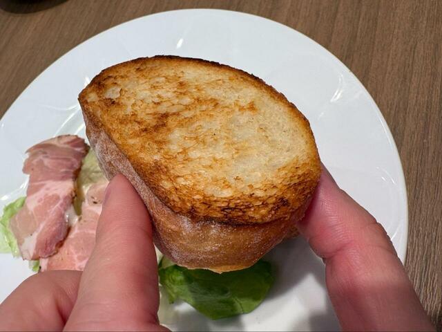 【デニーズ ローストポークサラダ 石窯ブール添え ドリンクつき】手に取るとわかる、表面カリッ中ふんわりの石窯ブールが主役級♪