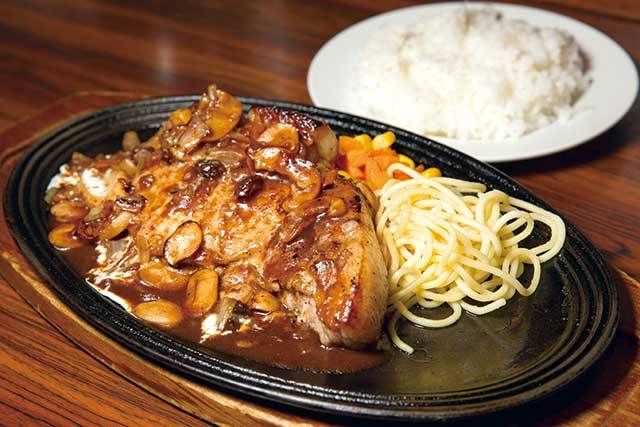 キッチン チェック（池袋）　ポークソテー ライス付 1200円　やわらかい国産豚肉にたっぷりかかったレーズン入りのデミグラスソースが食欲をそそる。