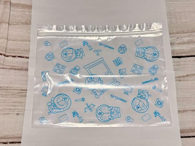 Lサイズは（約）縦22×横26cm。ライトブルーのドラえもんの総柄デザインです