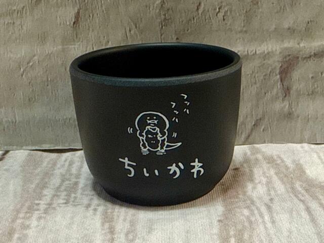 おちょこ1の背面。免許証を持っていってしまったトカゲがシーサーに餌付けされた様子が描かれています