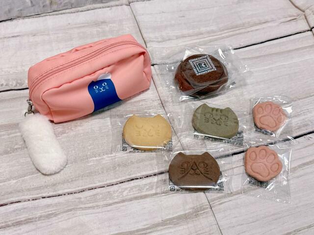 ねこのしっぽチャーム付きのポーチに、ねこの顔型クッキー、肉球型クッキー、バウムクーヘン（チョコ）が入った豪華なセット！