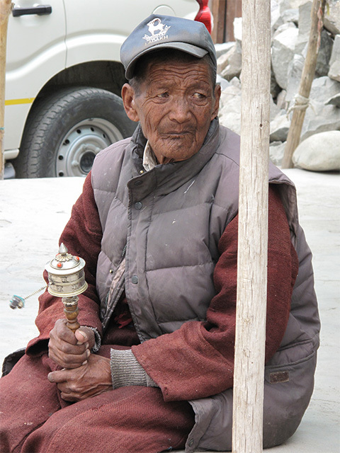 道端に座っていたおじいさん。チベット仏教名物、ぐるぐる回すと幸せになるらしいガラガラみたいな仏具を持っている。