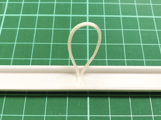 モール上内側の真ん中に、ヒモをテープで留めます