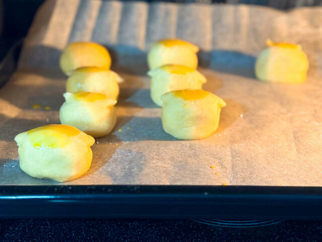 クッキングシートを敷いたオーブンの天板にくりまんじゅうたちを乗せます