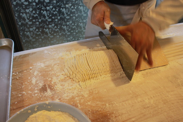 『イナンシジャン・カルククスチッ』の店頭で、包丁（カル）で切られるククス（麺）