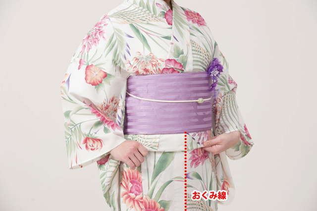 【おはしょりの直し方】帯の下に両手の人差し指を差込、おくみ線から両脇に軽くしごく