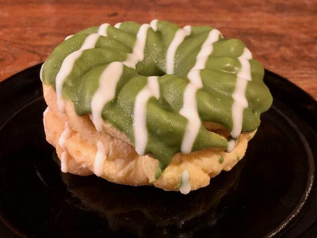 【ファミリーマート 濃い宇治抹茶のフレンチクルーラー】鮮やかな抹茶の緑色、白いアイシング、狐色の生地のコントラストが綺麗ですね