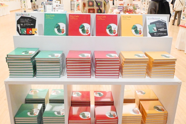 【エリック・カール展　はじまりは、はらぺこあおむし】「図録」は『はらぺこあおむし』であおむしが食べたものにちなんだ3色のバリエーションを用意。「りんご（赤）」「オレンジ（黄）」は数量限定です
