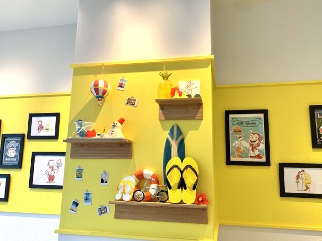 黄色い壁にリゾートを思い出させるアイテムが飾られている