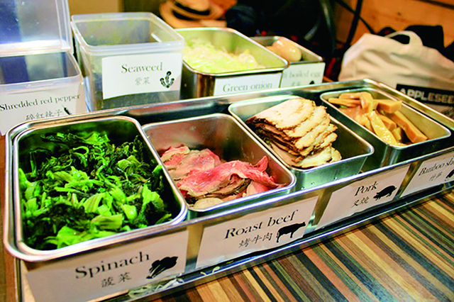 ラーメン体験のプロセス2：トッピング／メンマ、煮卵、ほうれん草など8種類の具材から選び、バランスよくトッピングする。