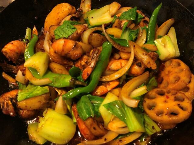 タマネギ、ピーマン、トウガラシなどを加えて弱火で混ぜながら味をなじませ、パクチーを入れればできあがり！