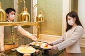 ブッフェレストランでのキャストによる料理の受け取りの様子