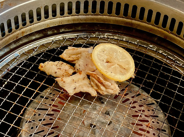 焼肉きんぐ：壺漬け一本ミノを食べやすい長さに切り、レモンをのせる