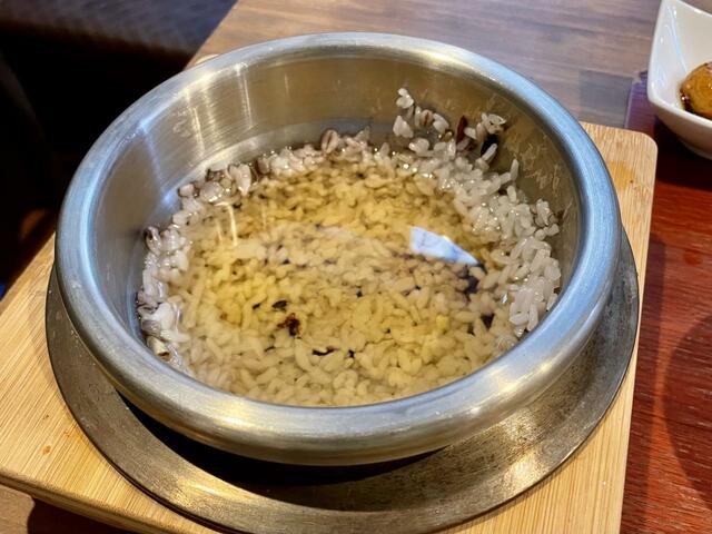 【釜めし 大統領】お茶を注いでもらったら5分待つ。ふやけたおこげご飯をスプーンかしゃもじで取りだし。スンドゥブにいれて食べる