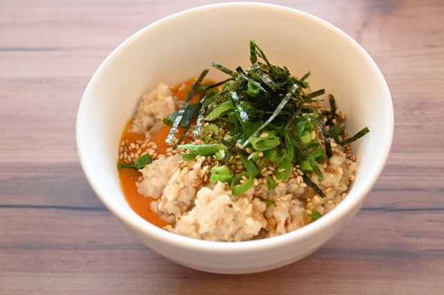 【卵かけオートミール】2．オートミールに卵、醤油、ごま油、ネギ・ごま・のりをのせる