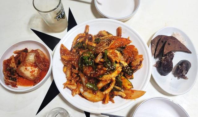 【気になる韓国、ソウルの今・忠武路】「ジンミネ」のイカ炒め（オジンオポックム）。右がつきだしの腸詰とレバー