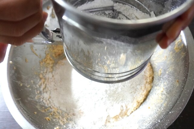 【〈塩分ハーフ〉ぐっち夫婦レシピ：味噌と黒豆のパウンドケーキ】残りの薄力粉、ベーキングパウダーを混ぜ合わせてふるいに入れ、1に少しずつ加える