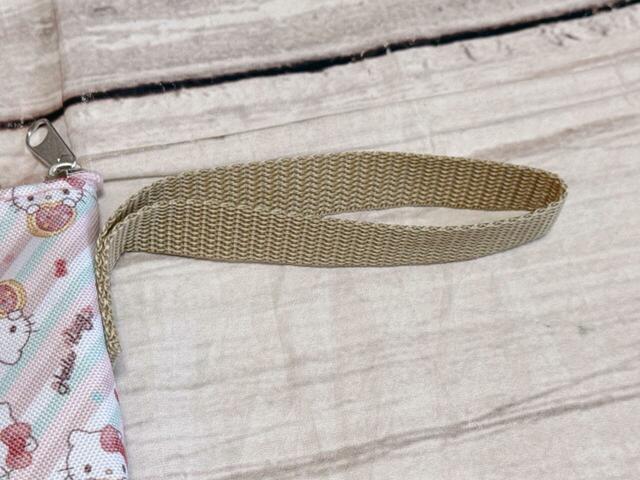 ストラップ付きで持ち運びの際に便利。ベージュカラーなので子どもっぽく見えず、大人でも持ちやすい配色◎【しまむら ペットボトルホルダー（ハローキティ）】