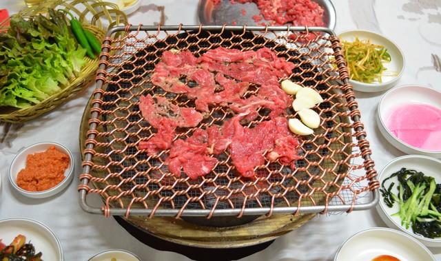 牛焼肉と副菜の一例。左手中央がミソ、左上がサンチュと青唐辛子。右上がネギのナムル、その下が大根スライス