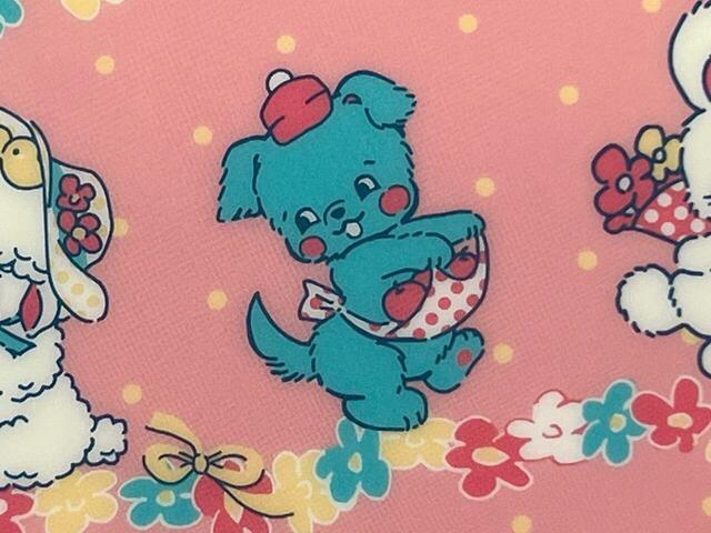 エプロンにりんごを入れて運んでいる犬。愛らしい表情です♪